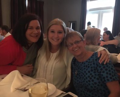 three smiling women seated at table