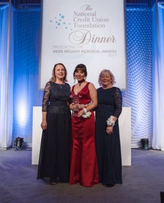 three well dressed women receiving award