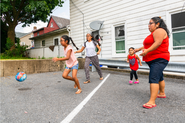 A Latino family playing in their yard.