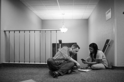 man and woman sitting on floor at top of stairs
