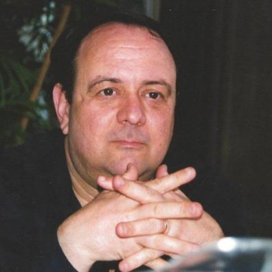 man with hands clasped near face