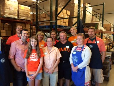 group of smiling people in warehouse