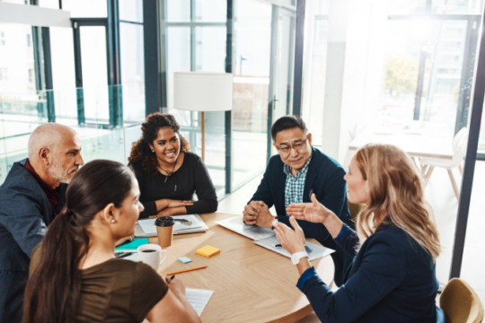 Group of employees sitting around table collaborating