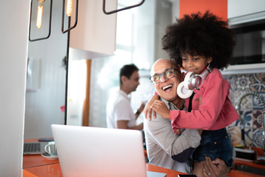 Happy father and daughter at laptop