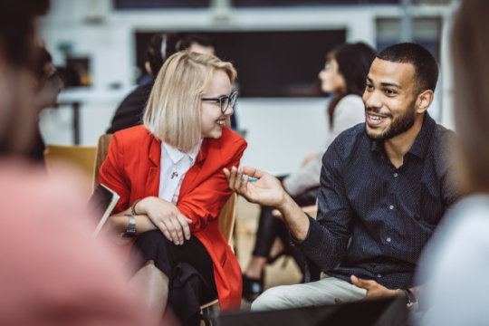 Man and woman at meeting talking and smiling