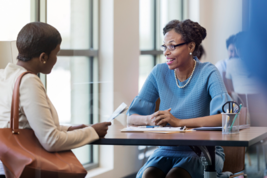 Two women talking at credit union