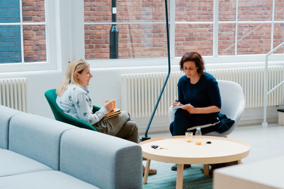 Two women discuss work at a breakout table