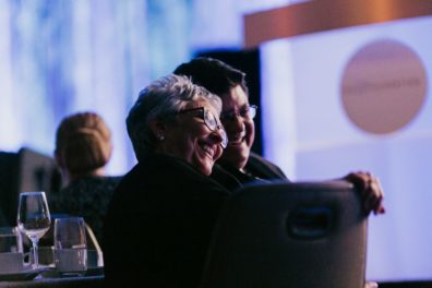 smiling couple sitting at table at awards dinner