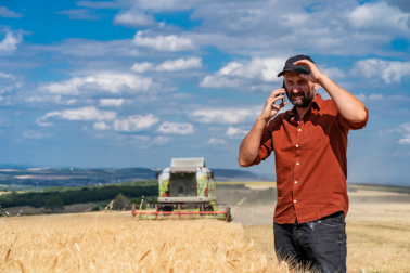 A Latino man stands in an active farming field.