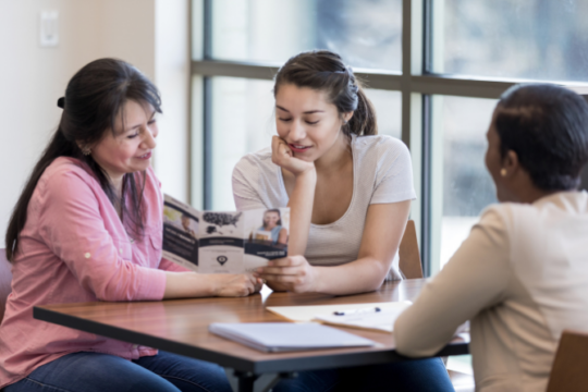 Young woman and mom review options at credit union