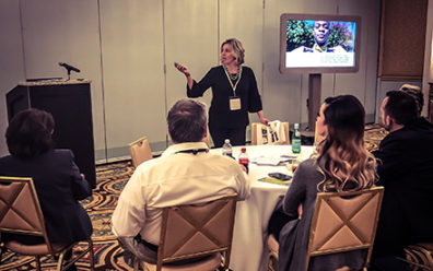 woman giving presentation to seated participants