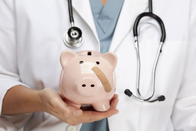 piggy bank with bandaid being held by doctor