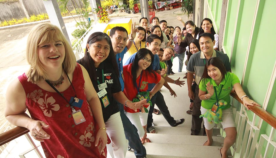 large group of smiling people in stairwell of building