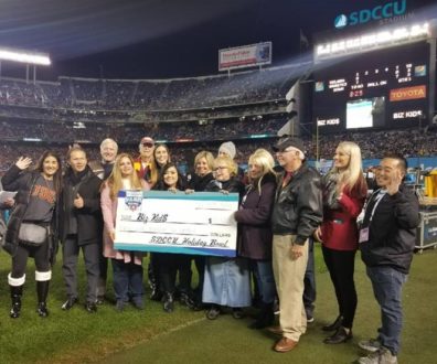 large group of people donating big check to Big Kids charity